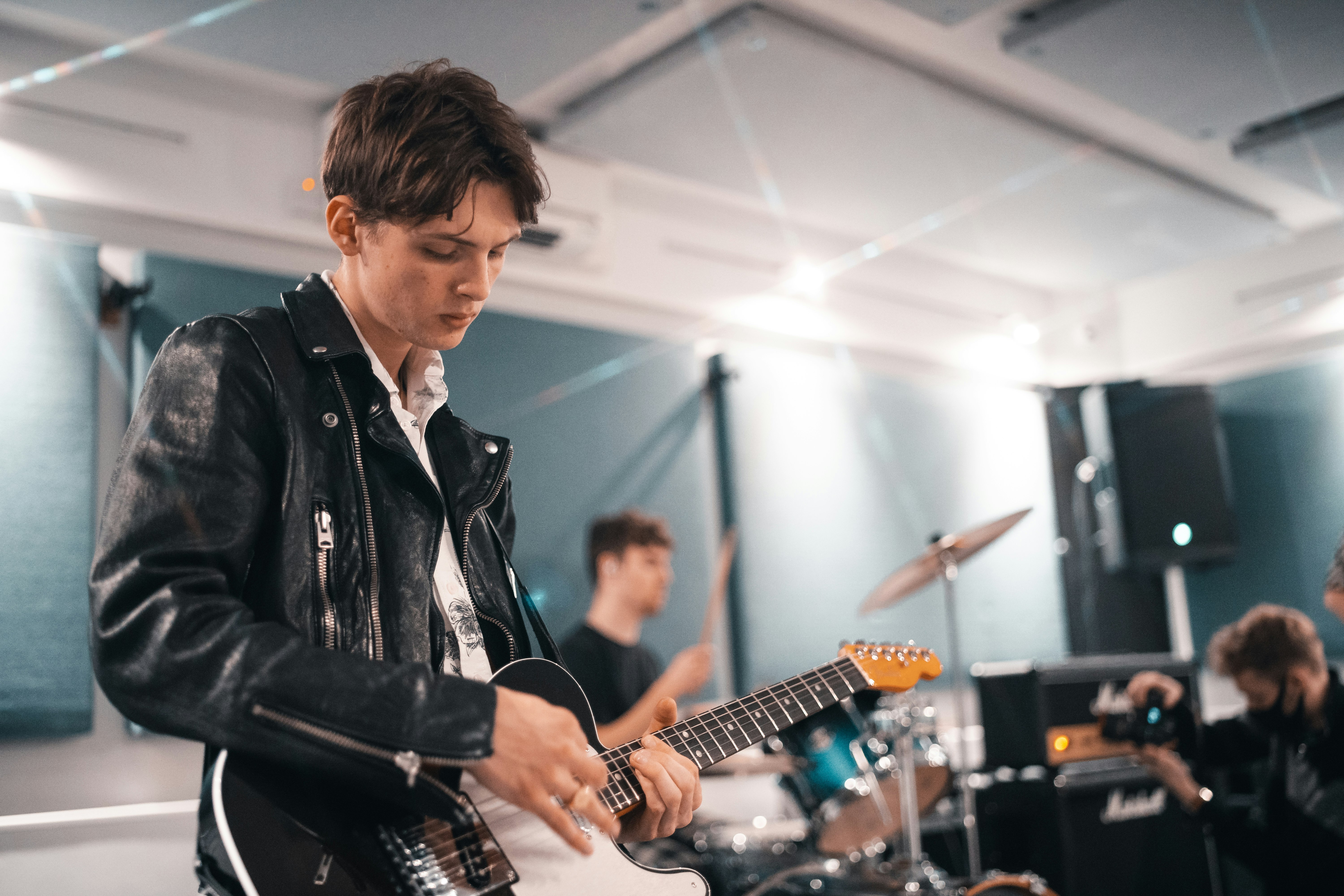 man in black leather jacket playing guitar